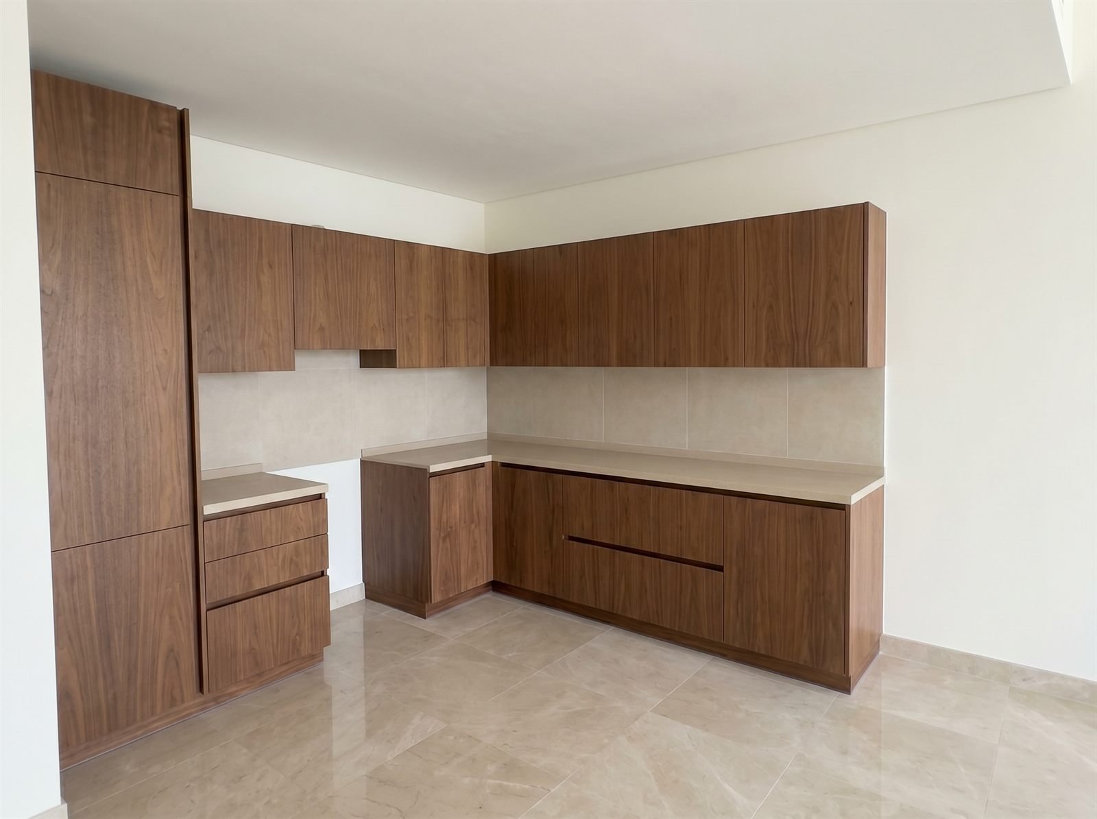 L-shaped fitted kitchen in walnut veneer with matched grain, Dubai