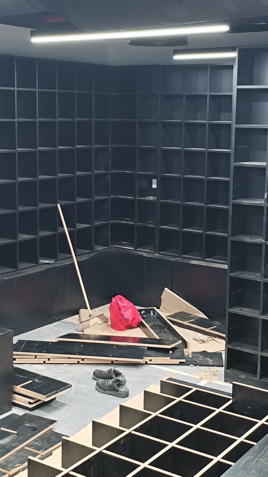 Black display shelving under installation on site, Dubai
