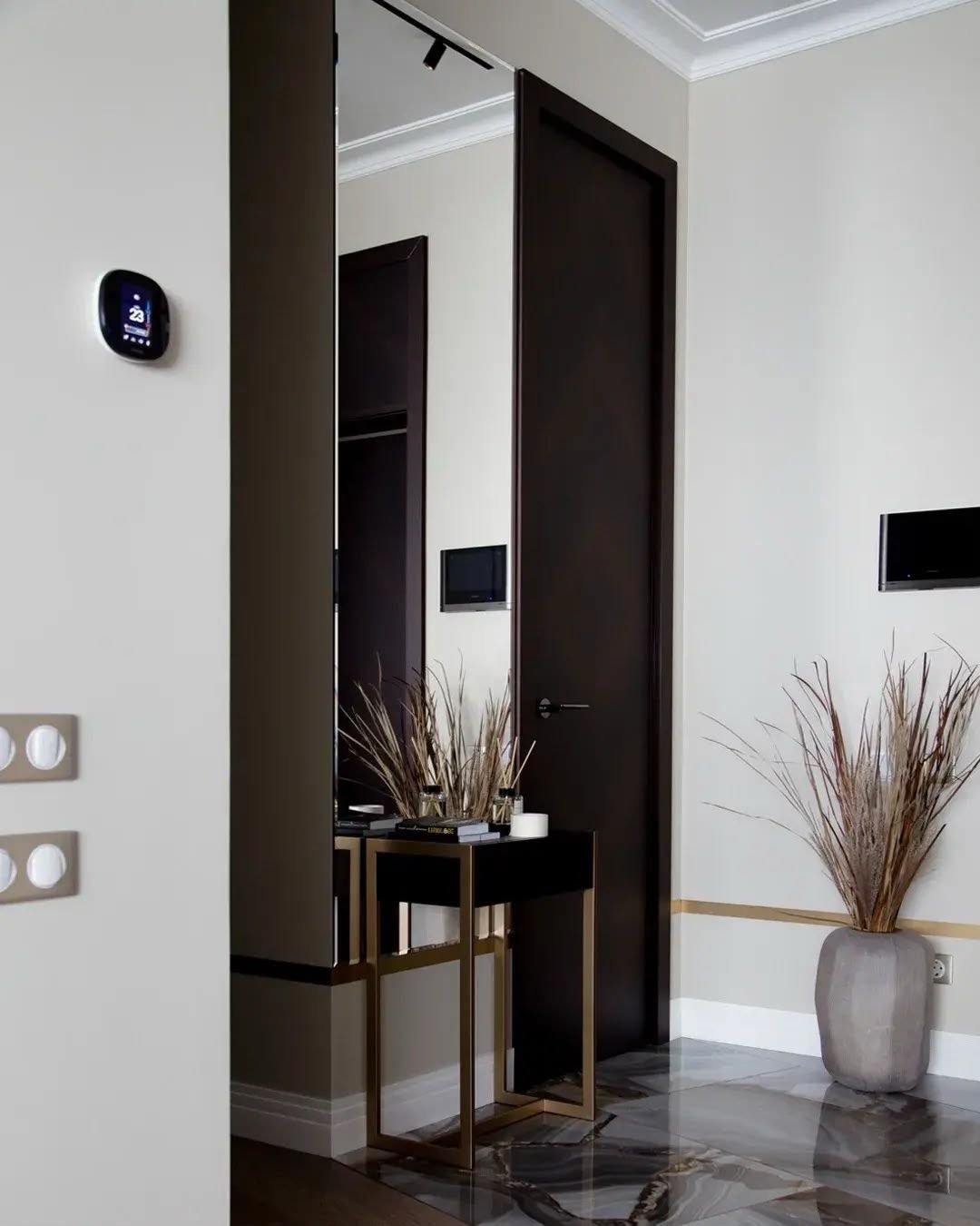 Entrance hall with console cabinet beside a black door, Dubai