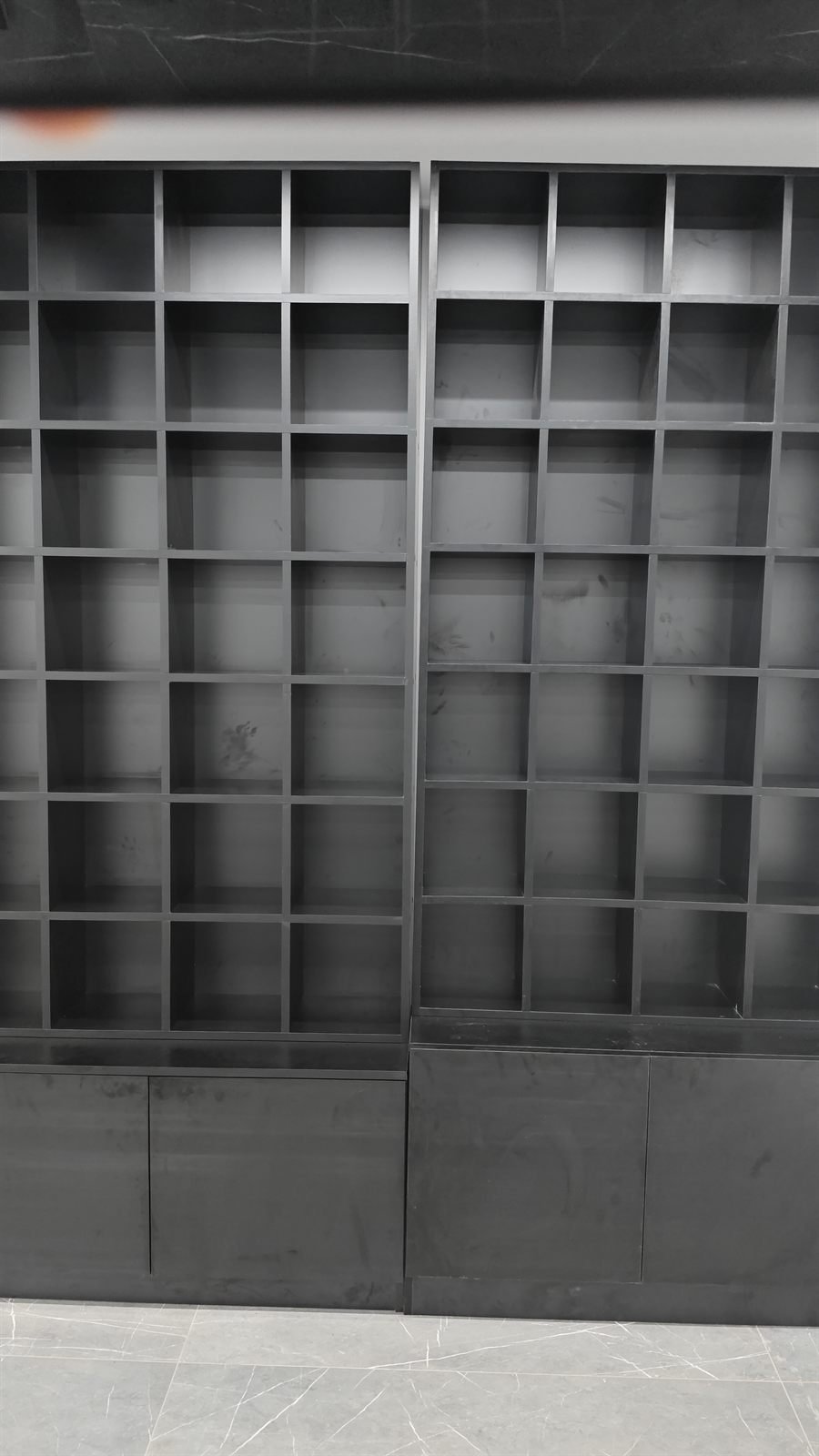 Floor-to-ceiling black display shelving during fit-out, Dubai
