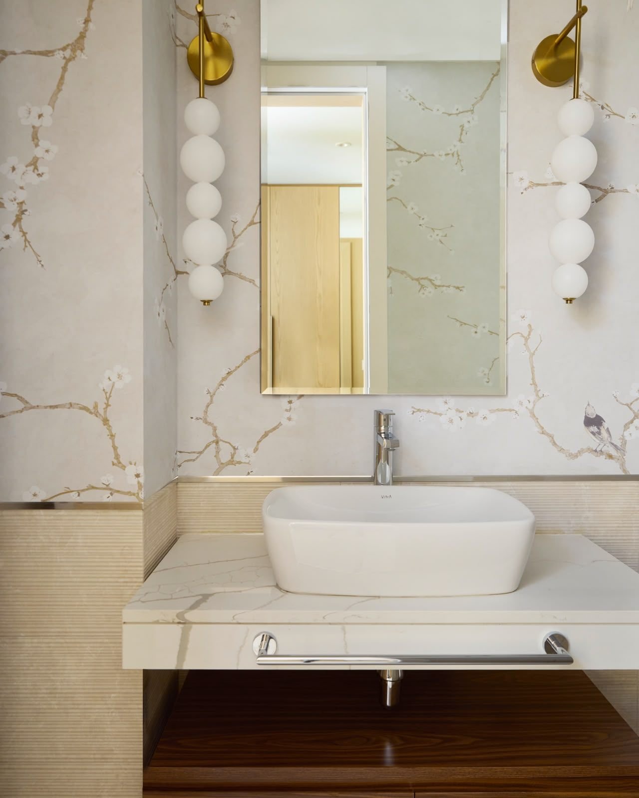 Powder room in marble with brass wall lights, Dubai